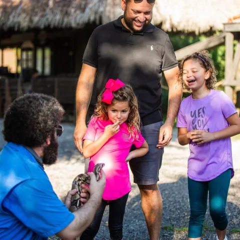 a little girl standing next to a man