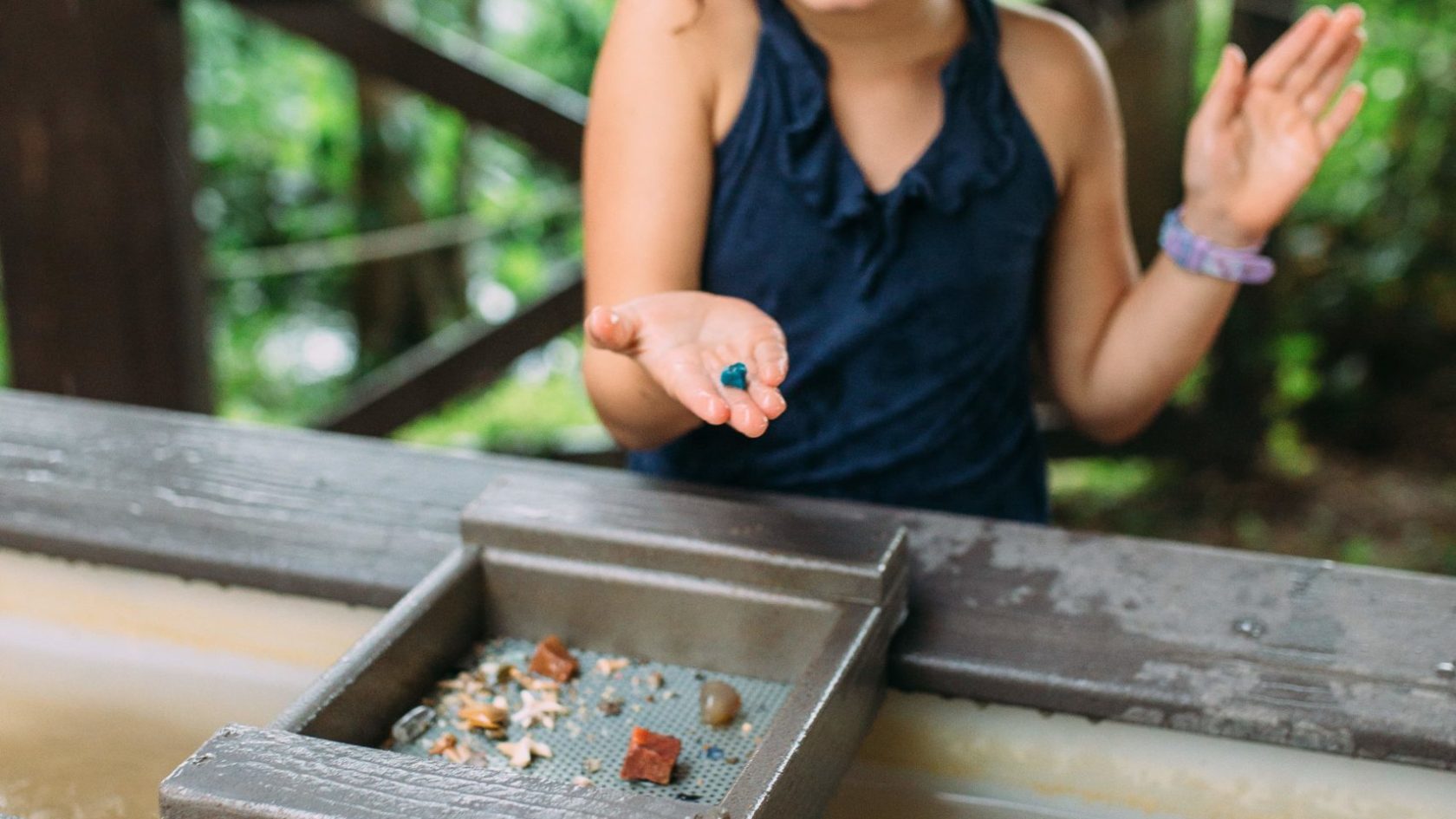 a girl sitting on a wooden bench