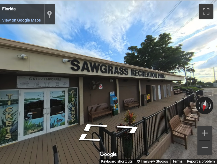Sawgrass Recreation Park entrance with benches and cloudy sky.